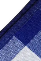 Detail van de afwerking van de blauw wit geruiten tafelkleden en servetten.
