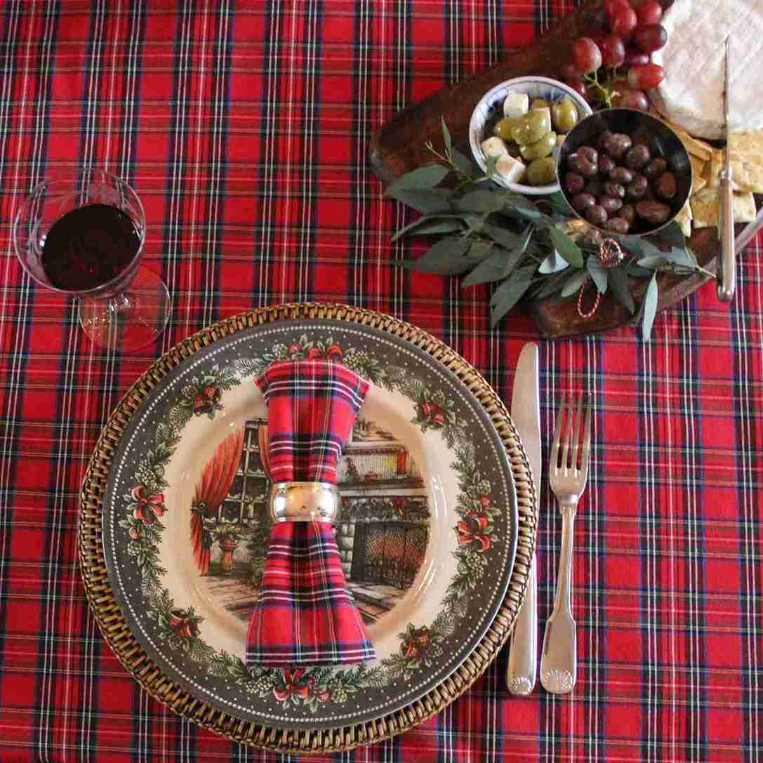 Gedekte tafel met rood schotse ruit tafelkleed en servetten.