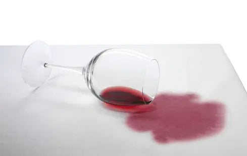 Omgevallen glas rode wijn op een tafelkleed