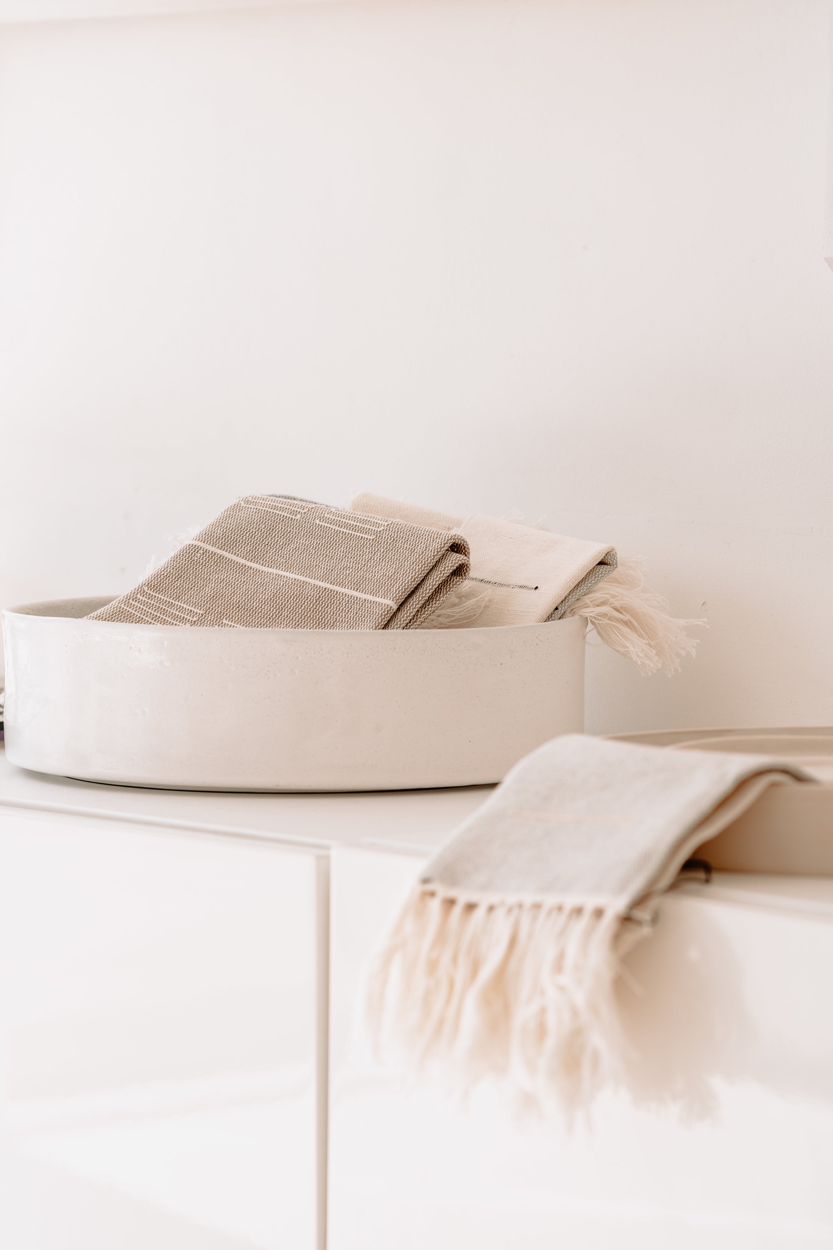 Gastendoekjes in een schaal op een dressoir gepresenteerd. Gebruik van naturel kleurige kleuren 